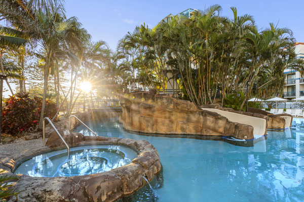 large swimming pool and jacuzzi at Oaks Calypso Plaza hotel resort in Coolangatta on Gold Coast at sunset