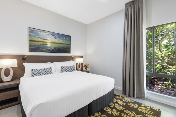 big double bed with clean white sheets and comfortable pillows next to large windows in 3 Bedroom Villa at Oaks Cable Beach Sanctuary hotel in Broome, Western Australia
